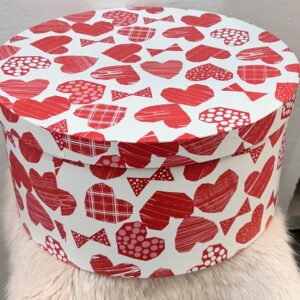 Caja de regalo redonda con diseño de corazones y lazos rojos